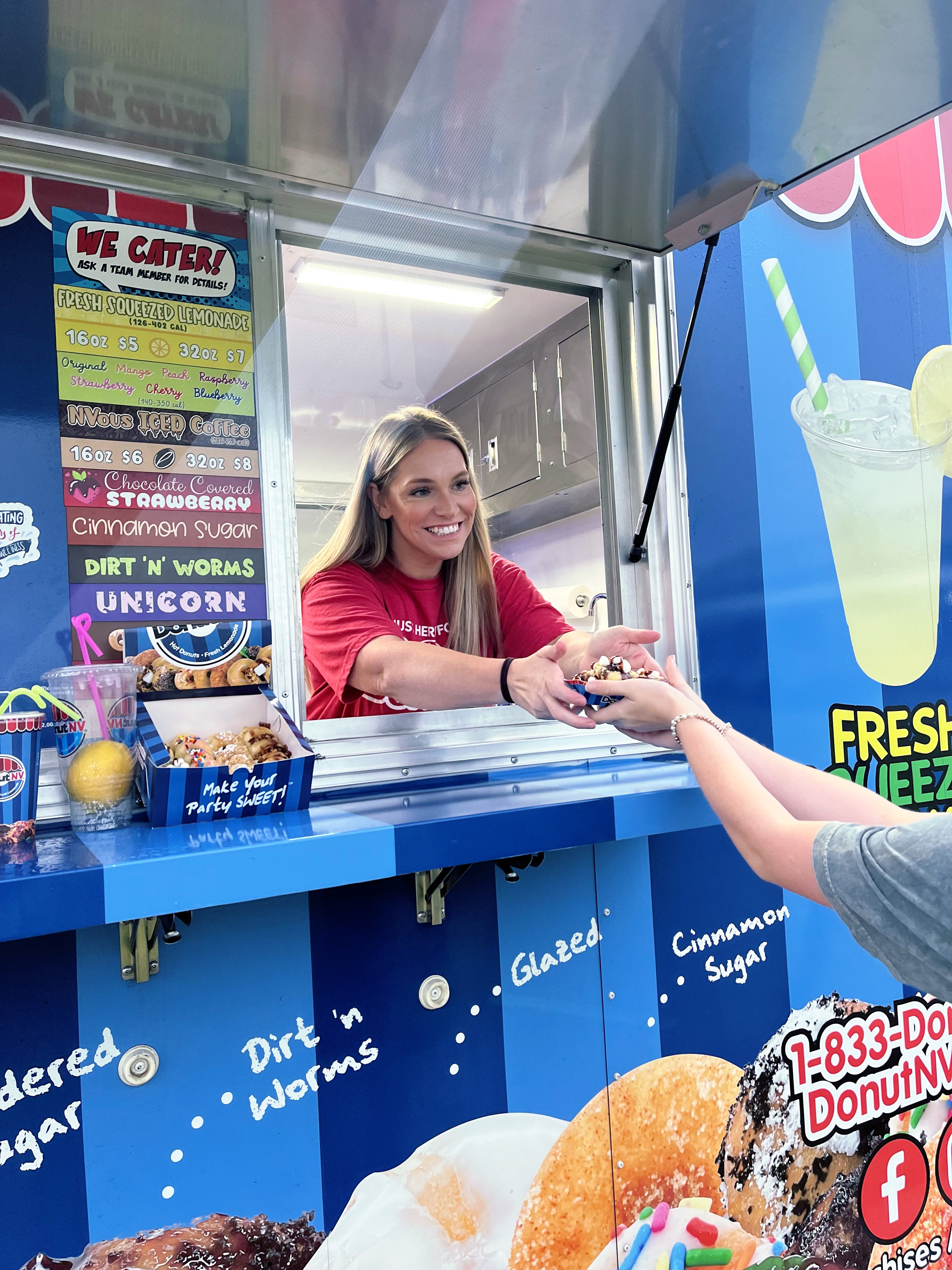 DonutNV operator handing fresh donuts through service window